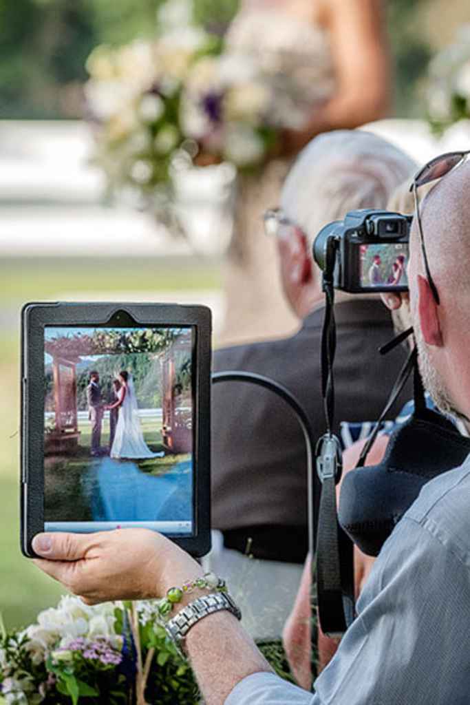 Svat na poroki snema poročni obred s tablico ter ga fotografira s fotoaparatom. Foto: Jamie Bosworth Photographer