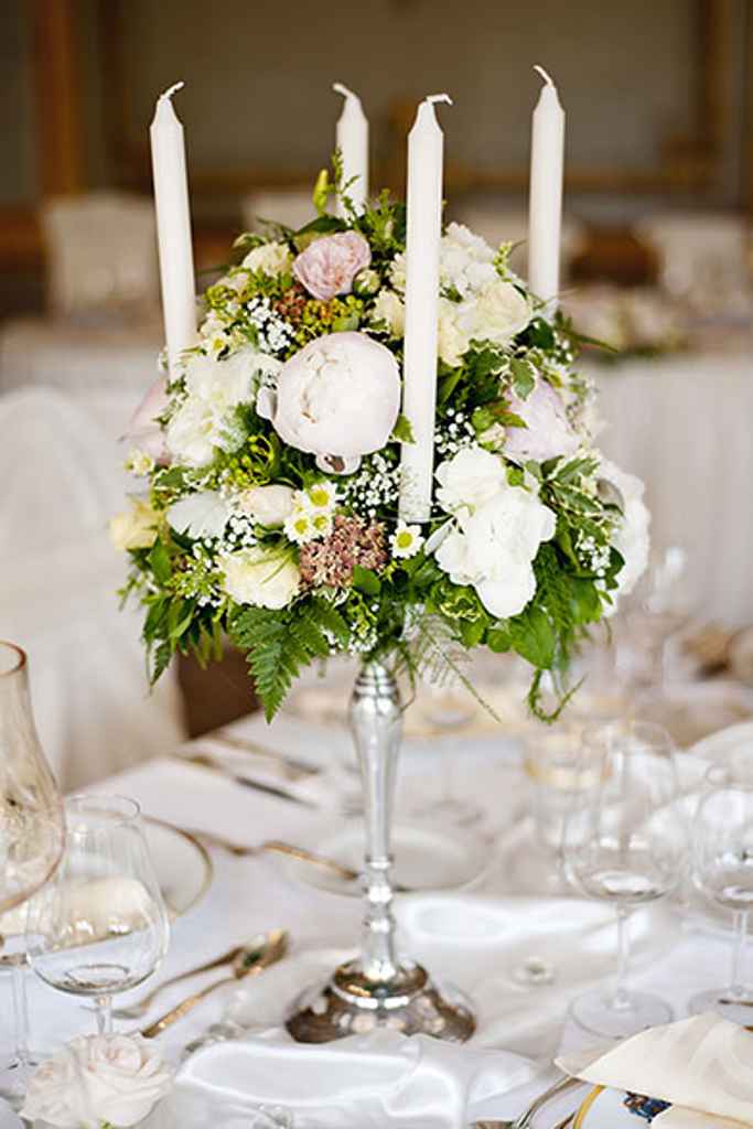 Prekrasen srebrni 5 kraki svečnik za poroko s sredinsko cvetlično dekoracijo postavljen na poročno mizo. Foto: arhiv Storija weddings