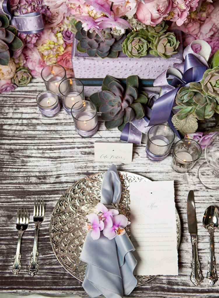 Eleganten rustikalni poročni pogrinjek, ki je sestavljen iz srebrnega pribora, keramičnega podkrožnika, sivega prtička okrašenega z roza cvetovi, menija in imenske kartice nad pod-krožnikom. Foto: vir Colin Cowie