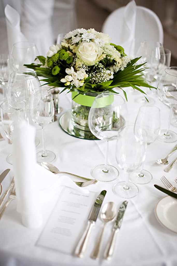 Poročni pogrinjek v hotelu Kempinski Palace Portorož sestavljen iz prtička, srebrnega pribora, kozarcev ter cvetlični aranžma v belo zeleni barvi. Foto: Rok Tržan Photography