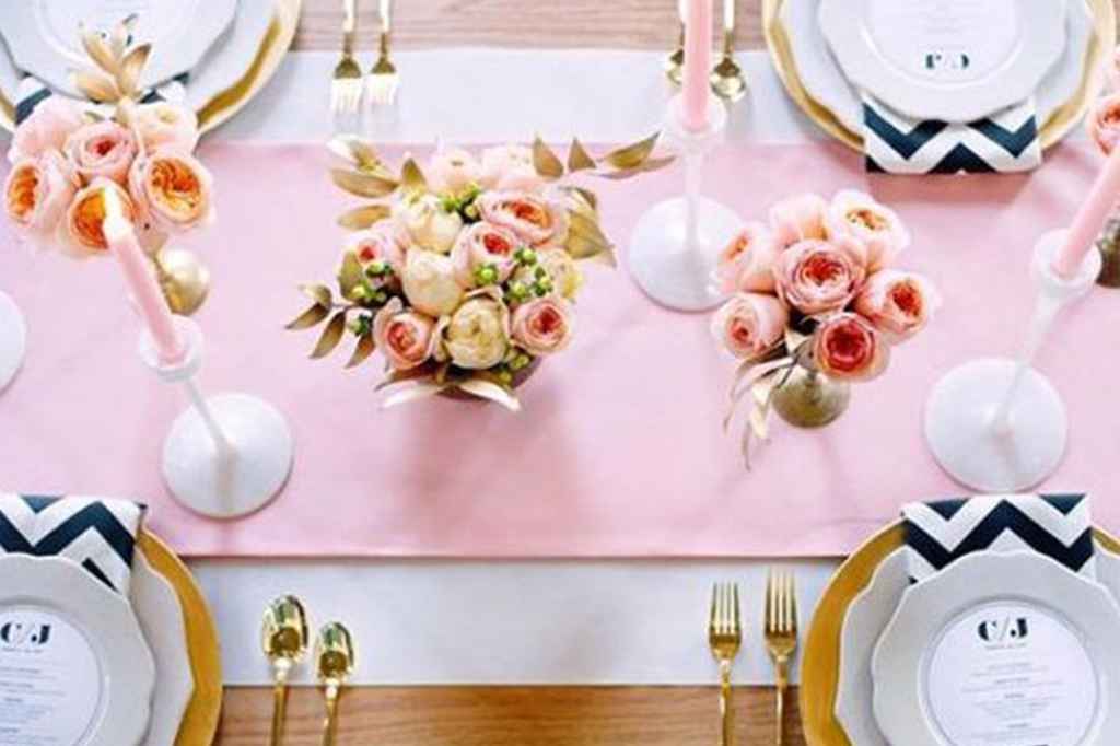 Umirjena dekoracija poročnega omizja z roza namiznim tekačem, belo črnimi cikcak prtički ter zlatimi svečniki in malimi cvetličnimi šopki. Foto: Paper Antler Photography