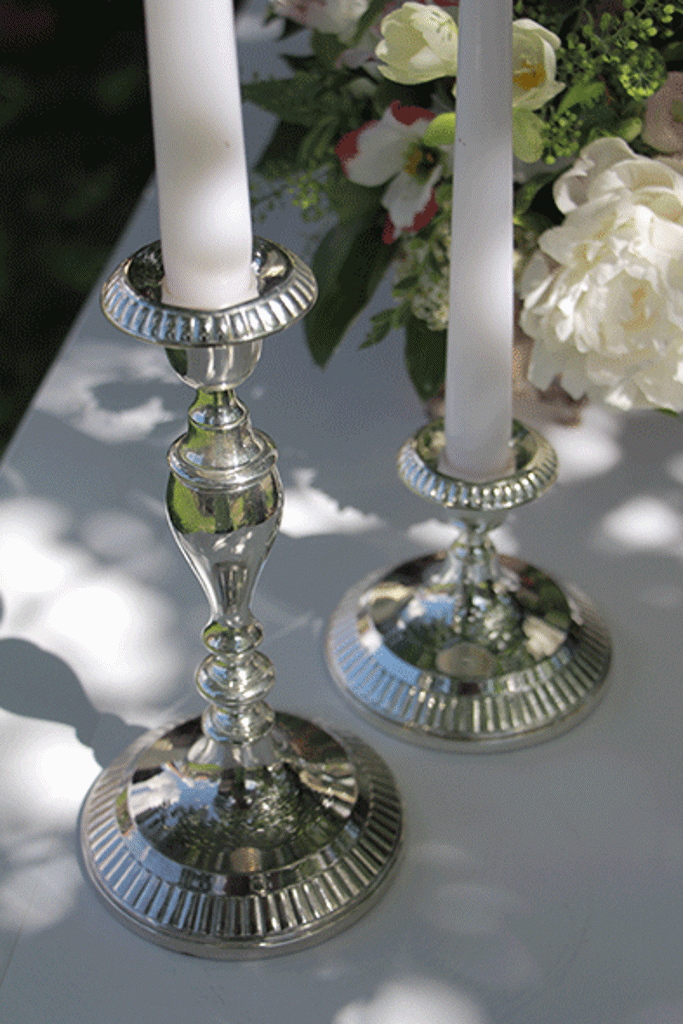 5 cm in 12 cm srebrni poročni svečniki za eno svečo stojita na belem kaminu. Foto: Storija weddings