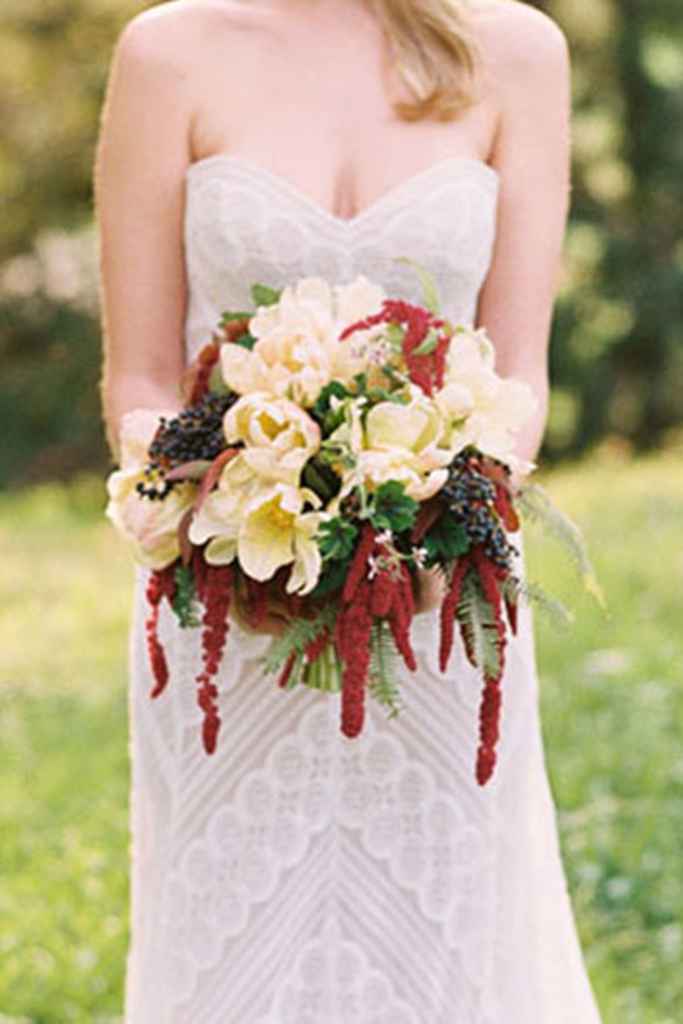 Nevesta drži v rokah razgiban boho poročni šopek iz različnega cvetja. Foto: Danielle Poff