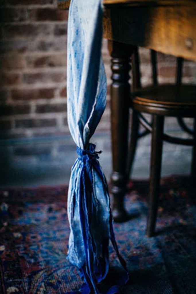 Dekoracija stola z modrim blagom pri poročnem omizju v vinski kleti. Foto: Tiffani Jones