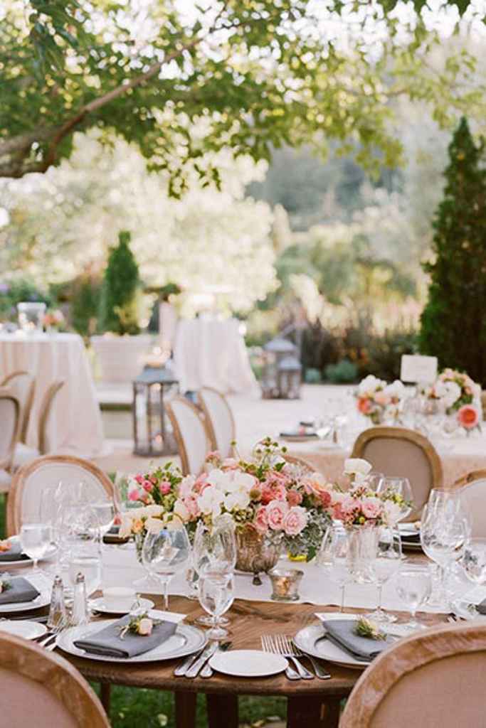 Prekrasna poročna postavitev z okroglimi mizami, pastelnimi cvetličnimi aranžmaji na sredini mize na vrtu dvorca Zemono. Foto: Sylvie Gil Photography