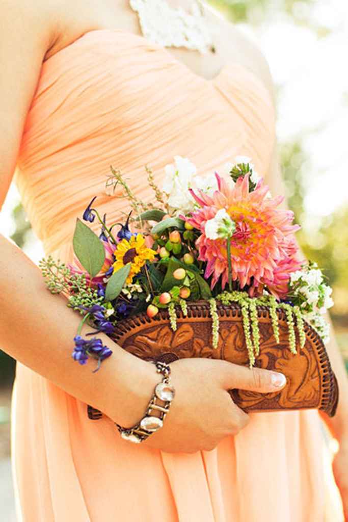 Poročni šopek iz travniškega cvetje je postavljen v majhno, usnjeno ročno torbico. Foto: Shannen Natasha Photography