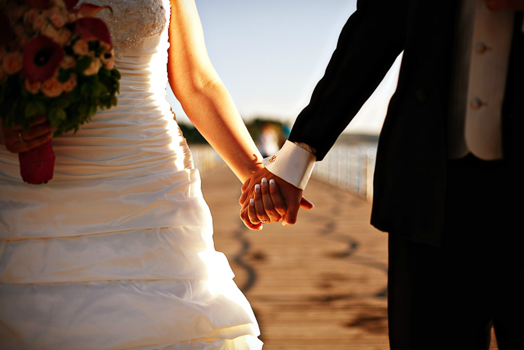 Poroka na morju. Nevesta in ženin se držita za roke na portoroški plaži. Foto: Aperturia weddings