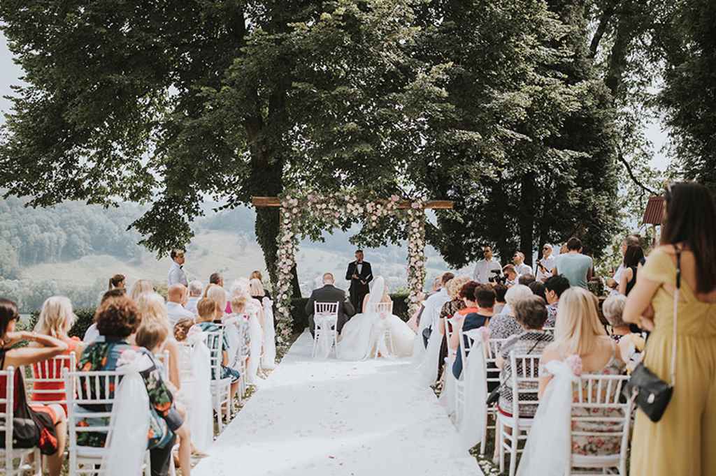 Poročni civilni obred v dvorcu Štatenberg pod drevesom in cvetličnim obokom ter belo preprogo. Foto: Ana Gregorič Photography 