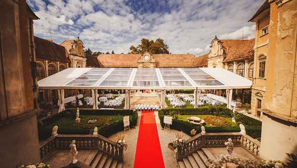 Dolga rdeča preproga vodi v prekrasen prozoren poročni šotor na dvorcu Štatenberg za poroko, ki jo je organizirala poročna agencija Storija weddings pod okriljem edinstvene načrtovalke porok Petre Starbek.
