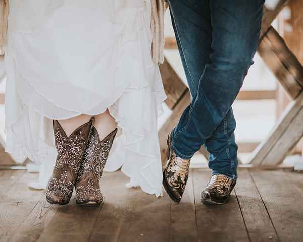 Nevesta in ženin v kavbojskih škornjih na tematski poroki na posestvu Pule. Organizacija porok vsebuje tudi dolačanje poročne teme in pomaga določiti vse elemente, ki bodo na poroki