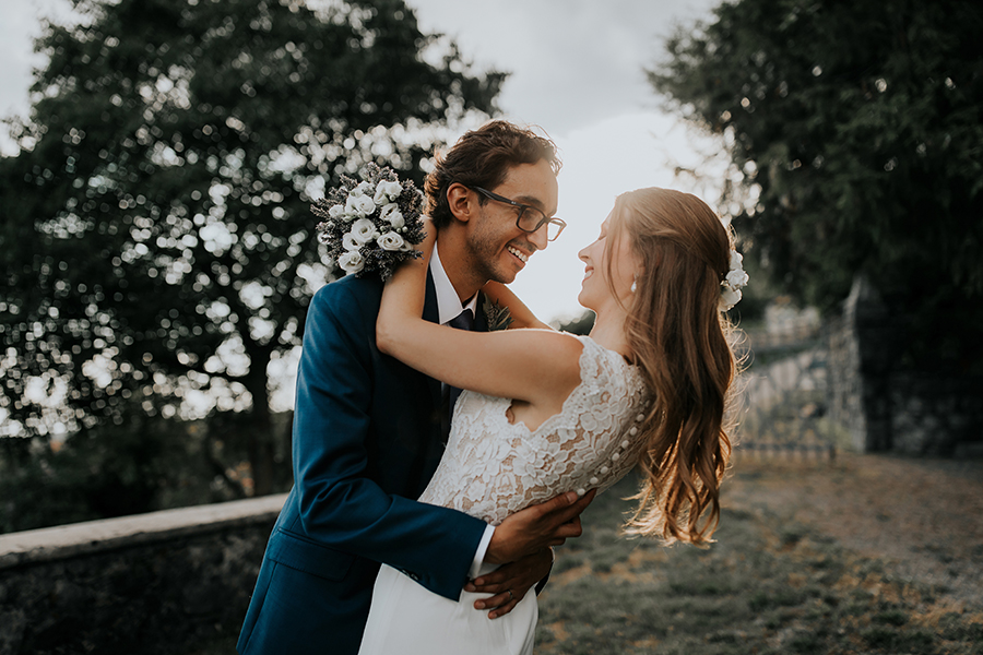 Par med poročnim fotografiranjem v Ferarrijevem vrtu v Štanjelu. Par se zaljubljeno gleda in uživa v druženju v objemu neokrnjene narave. Za organizacija poroke skrbi Petra Starbek.